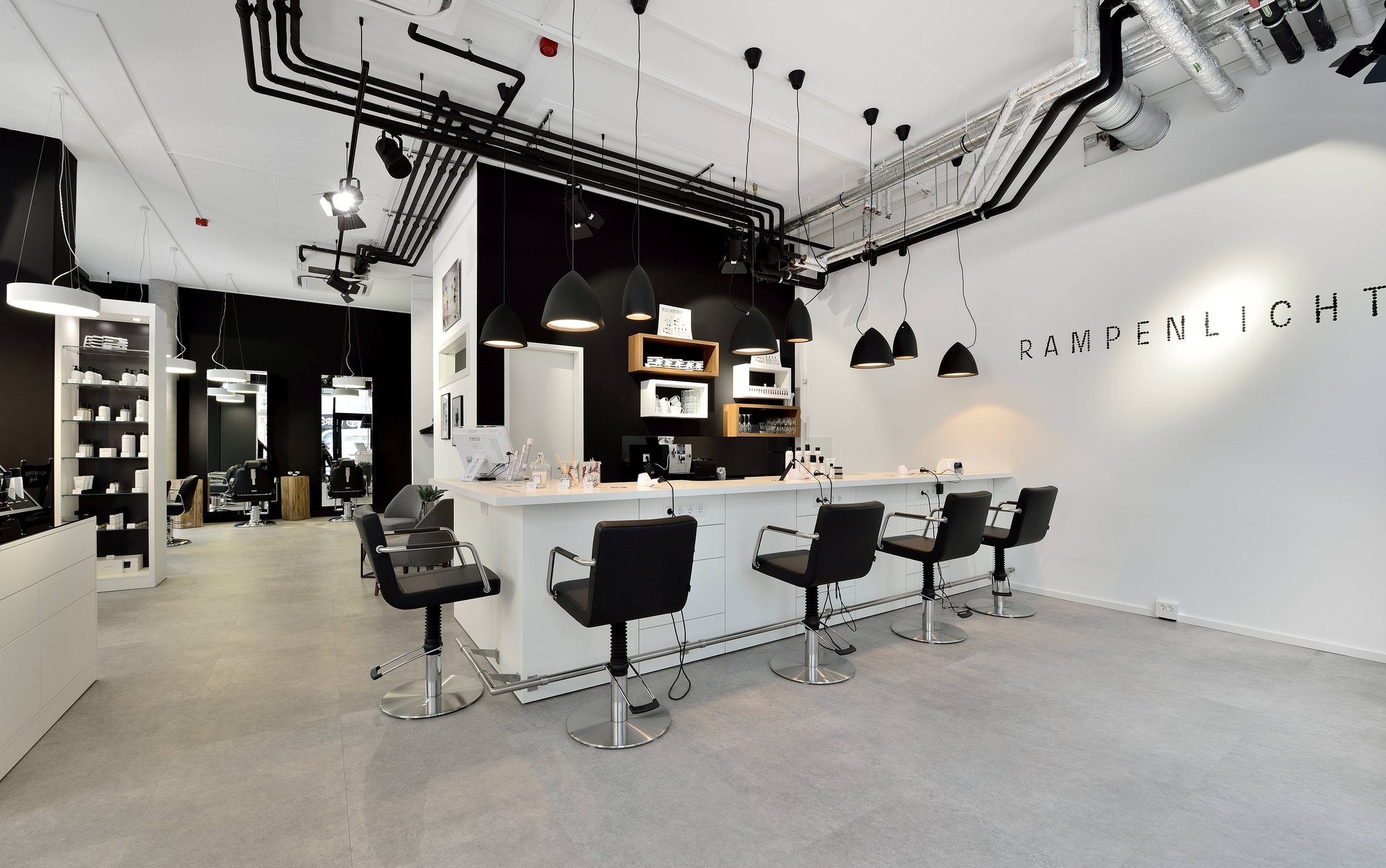 Salon in Schwarz-Weiß mit Bar und Hängeleuchten