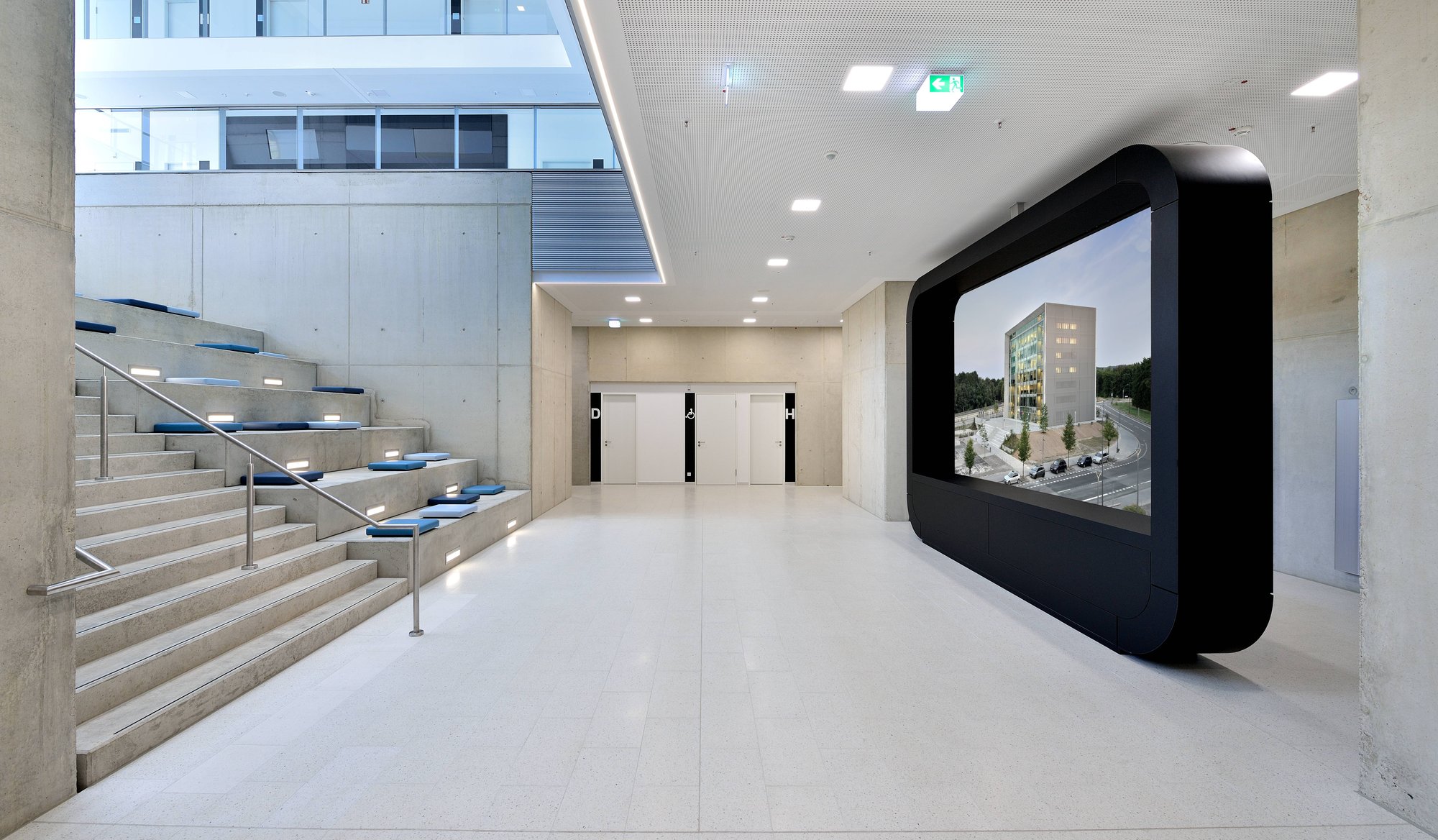 Foyer mit Sitzstufen und großem Bildschirm