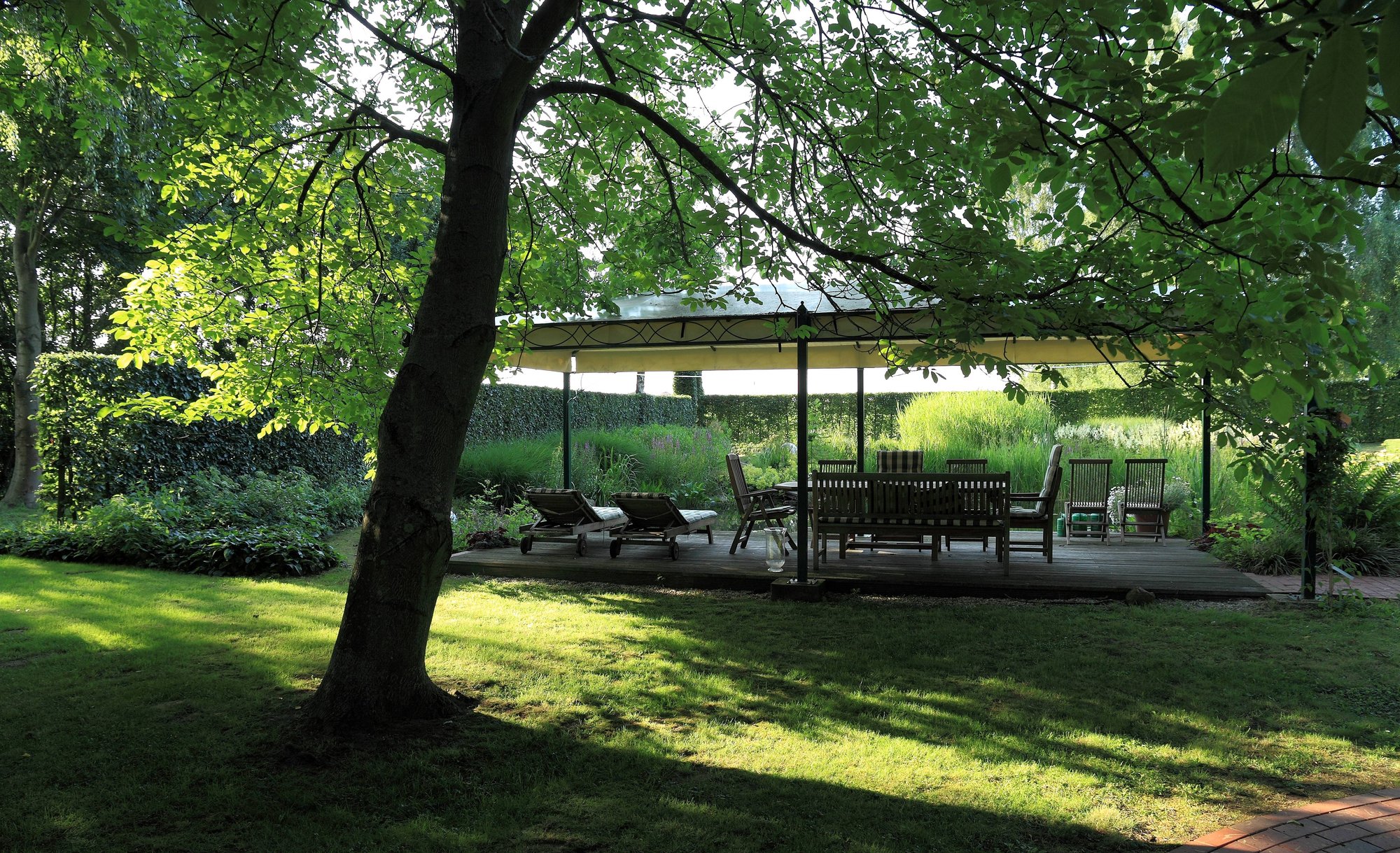 Gartenpavillon unter altem Baum
